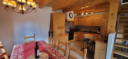eine Küche mit einem Tisch und einer Flasche Wein darauf in der Unterkunft Chalet Chez Cheryl, Mayens-de-Chamoson in Ovronnaz