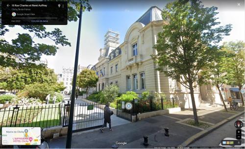 eine Person, die auf einem Bürgersteig vor einem Gebäude steht in der Unterkunft Très beau 2P avec vaste séjour ensoleillé - A 50 m du métro du marché et de la mairie in Clichy