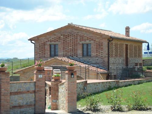 una casa in mattoni con un muro di pietra di Cosy agriturismo in Toscana with outdoor swimming pool a Peccioli