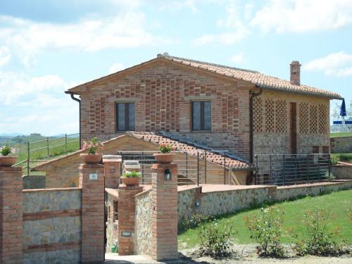 a brick house with a stone wall at Cosy agriturismo in Toscana with outdoor swimming pool in Peccioli