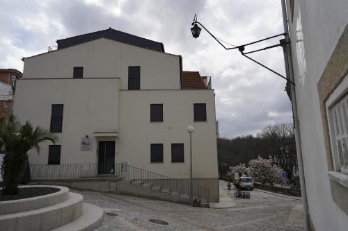 a white building with black windows on a street at Bemyguest - Loft Guest House Jardim das Mães Charming in Viseu
