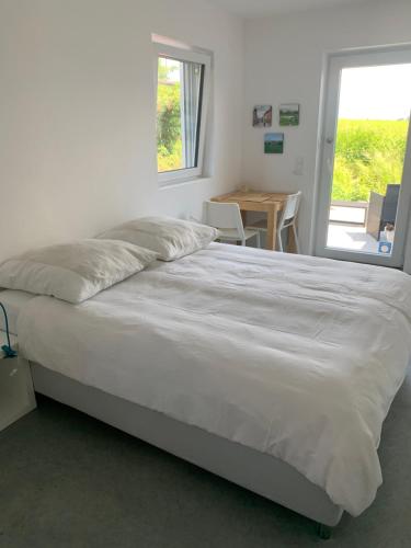 a large bed in a room with a table and a window at Studio mit Alpenblick in Kleinweil