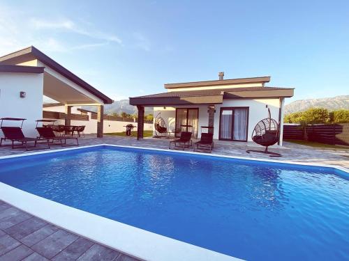 una gran piscina azul frente a una casa en Villa Domino, en Mostar