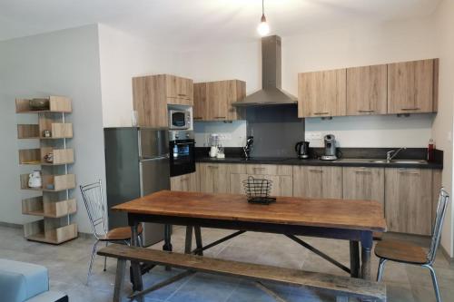 a kitchen with a wooden table and a refrigerator at Gite Les Promenades in Bellême