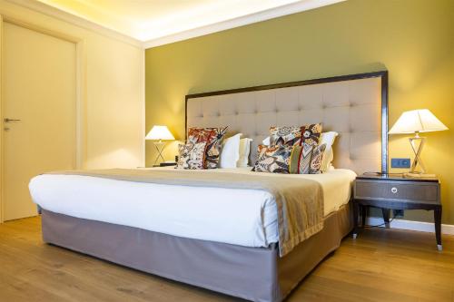 a bedroom with a large bed and two lamps at Hôtel Des Gouverneurs in Bastia