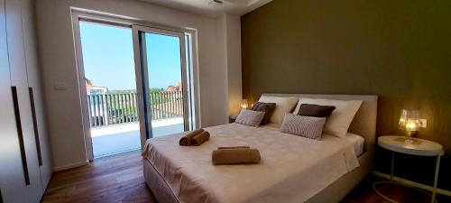 una camera da letto con un letto grande con una grande finestra di Villa Salvore - new luxury house, heated pool, near beaches, playroom - Istria a Savudrija