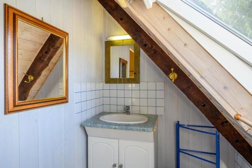 y baño con lavabo y espejo. en Petite maison dans la prairie, en Cléguérec