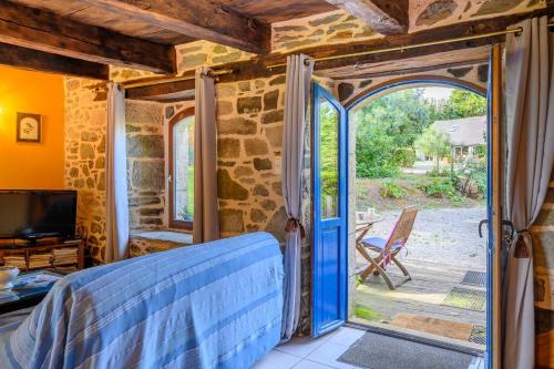 Zimmer mit einer offenen Tür zu einer Terrasse in der Unterkunft Petite maison dans la prairie in Cléguérec