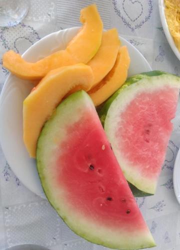 Un plato con rodajas de sandía y melón sobre una mesa. en Family Majčica - villa Malo Misto, en Klek