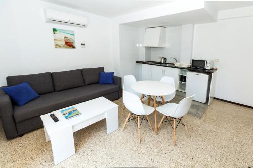 a living room with a couch and a table and chairs at Hostal El Mercat in Villajoyosa