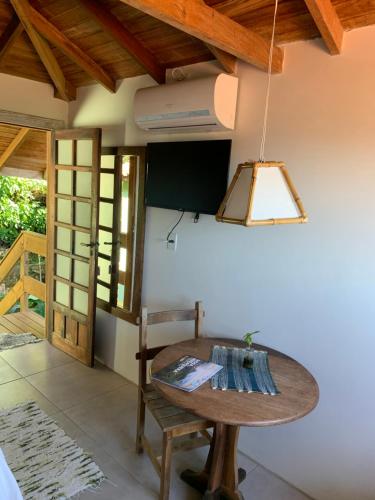 a dining room with a table and a lamp at Morada Sunset Praia do Rosa in Praia do Rosa
