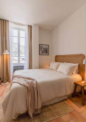 une chambre avec un grand lit et une fenêtre dans l'établissement L'Appartement du Coin, Beaulieu-sur-Mer, à Beaulieu-sur-Mer