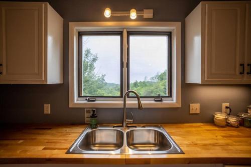 eine Küche mit einem Waschbecken und einem Fenster in der Unterkunft Mountainview (Secluded Retreat) in Canandaigua