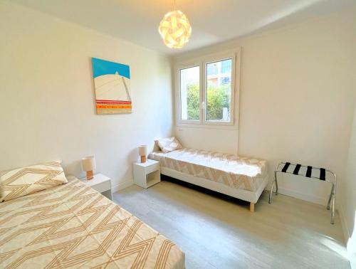 a bedroom with two beds and a window at La Cigale du Port in Cassis