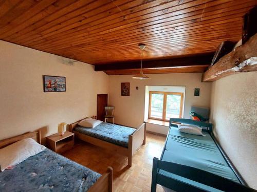 Dépaysement à la campagne في Saint-Martin-de-Sanzay: غرفة نوم بسريرين وسقف خشبي
