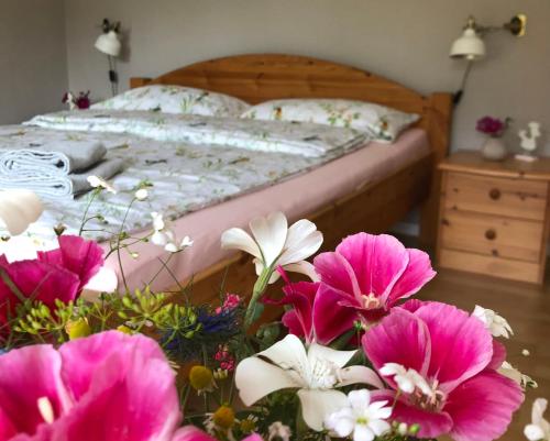 a bedroom with a bed with pink flowers on a table at Ferienwohnung Elbsegler in Bleckede