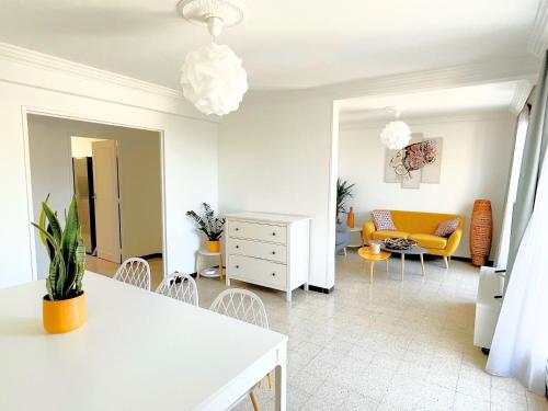 a living room with a white table and a yellow couch at La Cigale du Port in Cassis