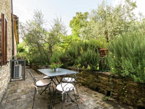 コルトーナにあるLuxurious cozy apartment with pool near Cortona in Tuscany versatileの庭園付きのパティオ(テーブル、椅子付)