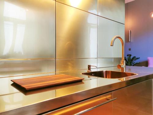 una cocina con encimera de acero inoxidable y fregadero en Butikowy apartament w centrum Warszawy, en Varsovia