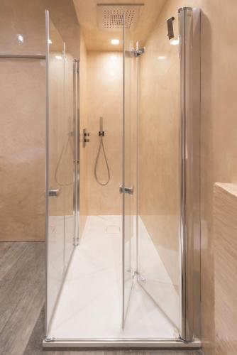 a shower with a glass door in a bathroom at Casa Duccio alle Mura della Città in Siena