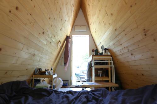 um quarto com uma cama, uma janela e uma mesa em A-frame cabin iwor - Vacation STAY 36172v em Shimokawa