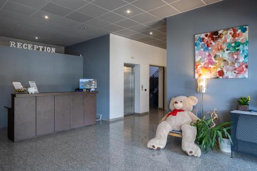 a large teddy bear sitting in a waiting room at Hotel Fontaine Bleue in Orta San Giulio