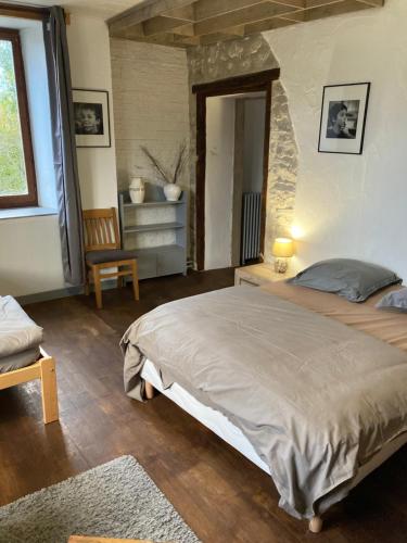 ein Schlafzimmer mit einem großen Bett in einem Zimmer in der Unterkunft le Châtelet in La Chaux Neuve