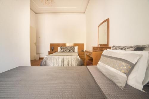 a bedroom with two beds and a mirror at Residencial Valentina in Lisbon