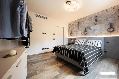 a bedroom with a bed and a brick wall at Casa Duccio alle Mura della Città in Siena