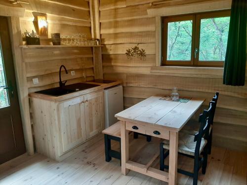 a kitchen with a sink and a table in a cabin at Le Jardin Des Cabanes in Gilly-sur-Loire