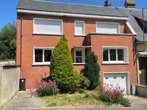 une maison en briques rouges avec un arbre en face de celle-ci dans l'établissement Maison - Louviers centre - proche golf, à Louviers