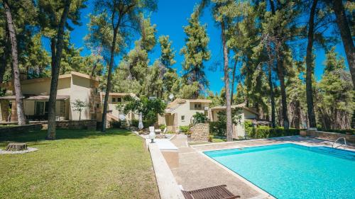 a house with a swimming pool and trees at Sani Cape Shared Pool Villas in Sani Beach