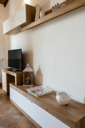 a living room with a counter with a tv and a table at Casa Vacanze La Perla del Lago in Passignano sul Trasimeno