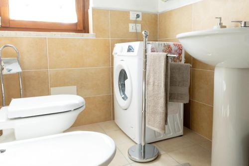 a bathroom with a toilet and a sink and a washing machine at Casa Vacanze La Perla del Lago in Passignano sul Trasimeno