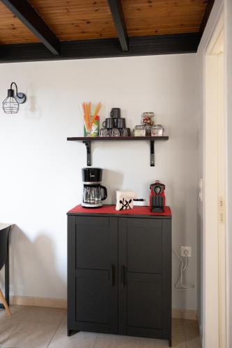 a kitchen with a black cabinet with a red counter top at Minimal loft at Kastellokampos in Patra