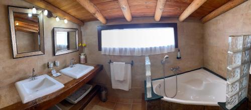 a bathroom with two sinks and a bath tub at Alhanda Apartahotel in Benamaurel