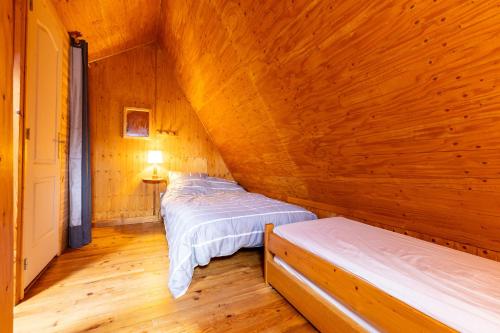 Dos camas en una habitación con paredes de madera. en Chalet Sérénité - Tranquillité et Très Belle Vue, en Puyvalador