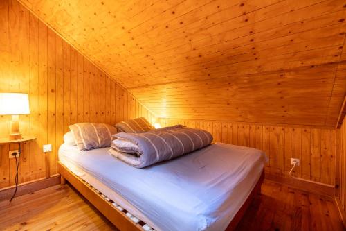 Un dormitorio con una cama en una habitación de madera. en Chalet Sérénité - Tranquillité et Très Belle Vue, en Puyvalador