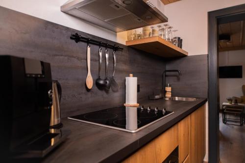 a kitchen with a stove and a sink with utensils at Mountainlodge Tirol Berwang in Berwang