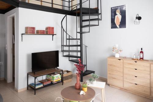 a living room with a spiral staircase and a television at Minimal loft at Kastellokampos in Patra