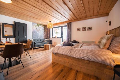 a bedroom with a large bed in a room with wooden ceilings at Mountainlodge Tirol Berwang in Berwang
