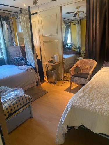 1 dormitorio con 2 camas y espejo en Big Home in London, Forest Hill en Londres