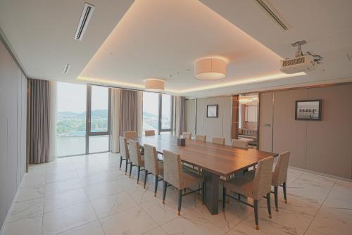 a dining room with a wooden table and chairs at Hotel Marinabay Seoul Ara in Gimpo