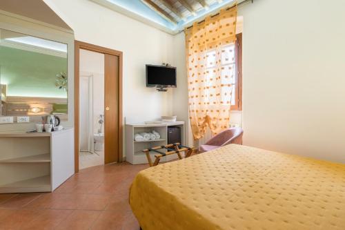 サンタ・ルーチェにあるPodere Cortesi Agriturismo Molinaccioのベッドとバスルーム付きのホテルルームです。
