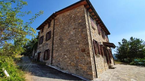 un antiguo edificio de piedra con ventanas laterales en Il Bordone del Pellegrino en Terenzo