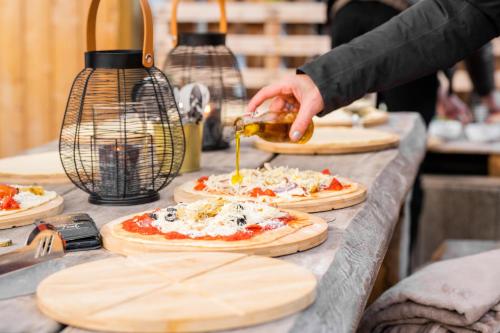 a person is making pizzas on a table at Mountainlodge Tirol Berwang in Berwang