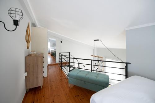 a bedroom with a bed and a stair railing at Minimal loft at Kastellokampos in Patra