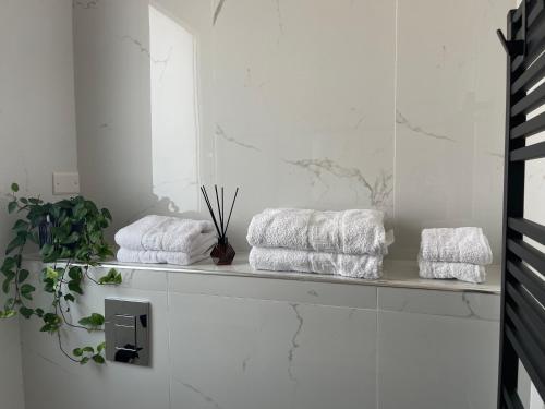 a white bathroom with towels on a shelf at Martanna Rooms in Carini