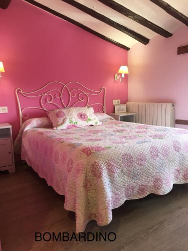 różowa sypialnia z łóżkiem i różową ścianą w obiekcie Casa Rural La Corchea w mieście Elciego