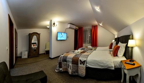 a hotel room with a bed and a television at Noblesse House Deva in Deva